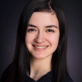 Chelsea's headshot. Light-skinned, young feminine-presenting half-Asian half-white professional with black hair.